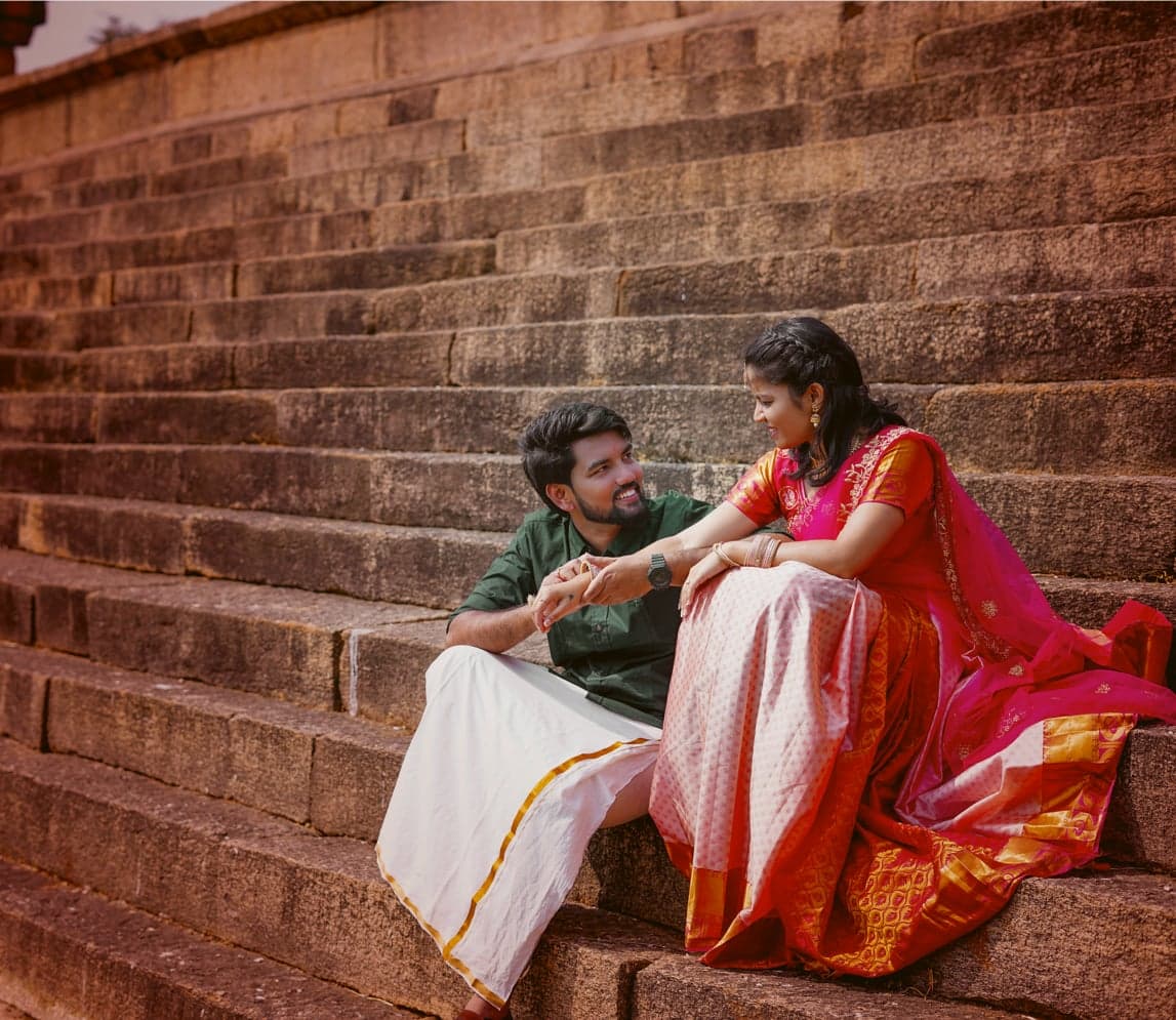 Couple sitting together on ancient stone steps during their engagement ceremony